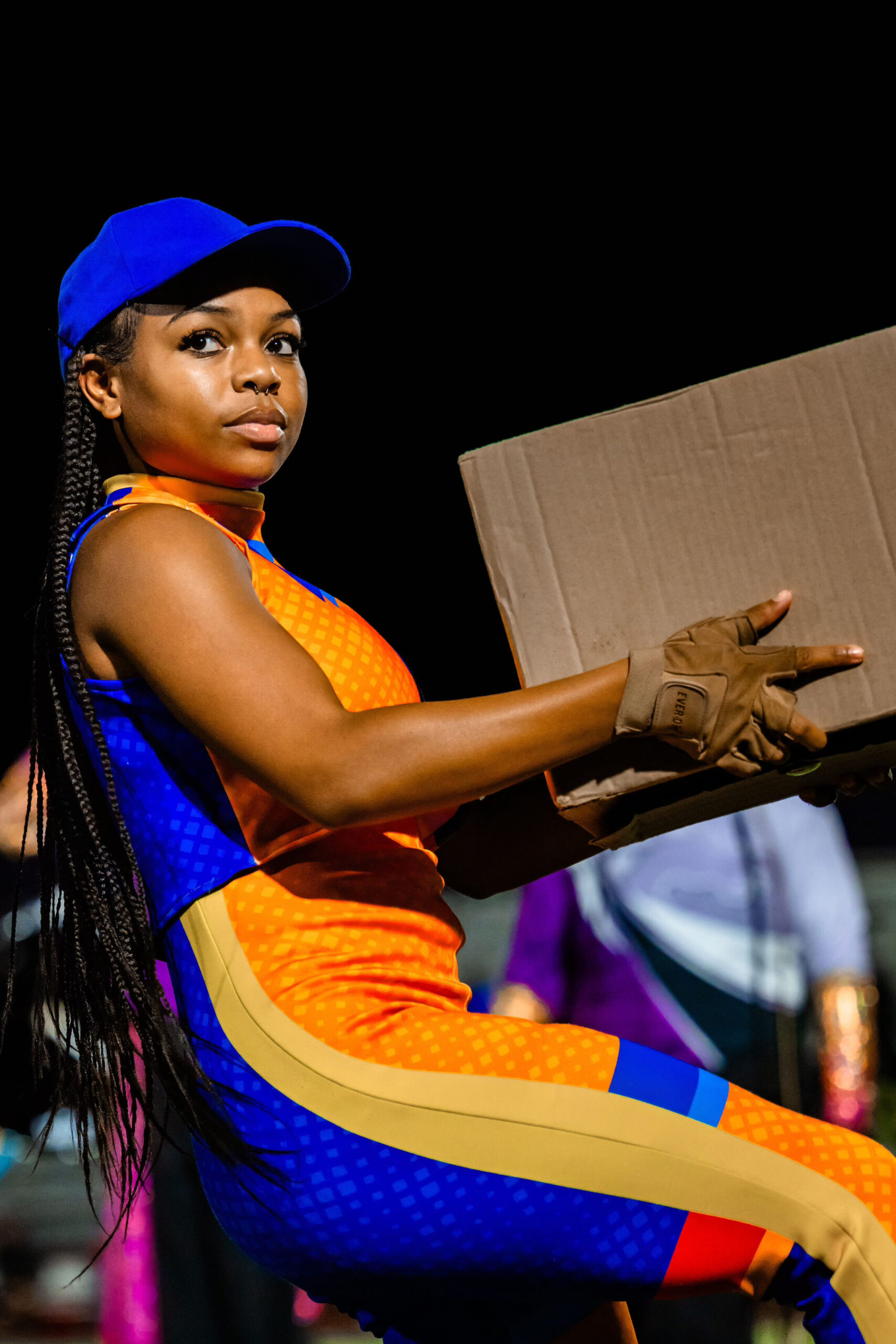 color guard girl holding a cardboard box